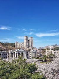 Buildings in city against blue sky