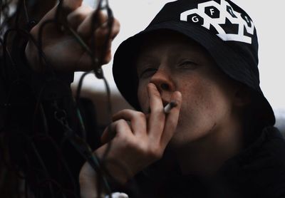 Close-up portrait of man holding mobile phone