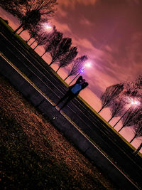 Illuminated railroad tracks against sky at night