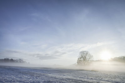 Scenic view of snowy field against sky during winter