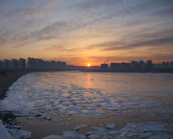 View of frozen river during sunset