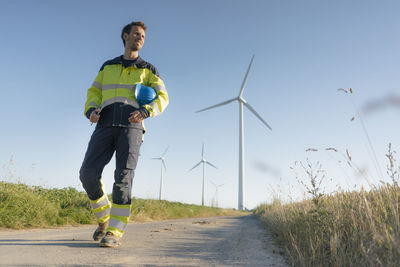 Engineer walking on field path at a wind farm