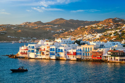 Sunset in mykonos, greece, with cruise ship and yachts in the harbor