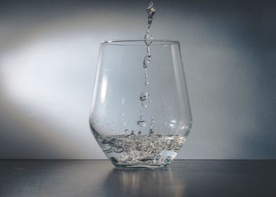 Close-up of water pouring in glass on table