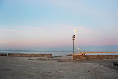 Lighthouse by sea against sky