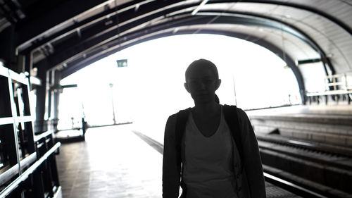Rear view of man standing at railroad station