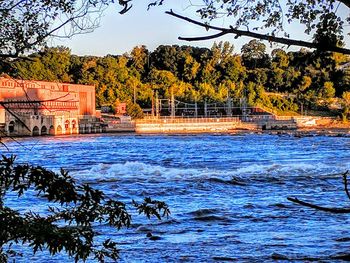 Scenic view of river by building against sky