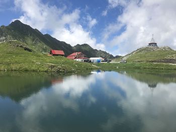 Scenic view of lake by buildings against sky