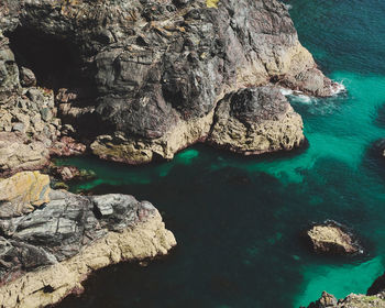 Rock formation in sea at kynance cove in cornwall, england