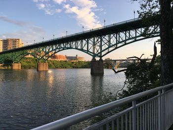 Bridge over river in city against sky