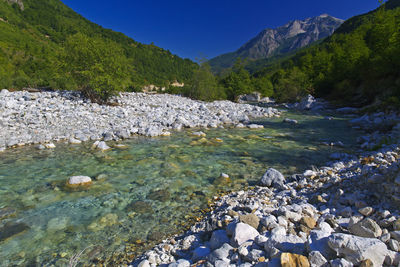 Scenic view of lake by mountains against sky