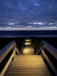 Wooden pier over sea against sky