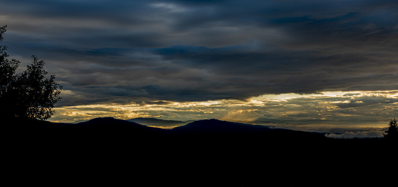 SCENIC VIEW OF SILHOUETTE MOUNTAINS AGAINST DRAMATIC SKY