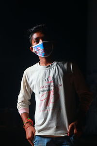 Full length of a boy standing against black background