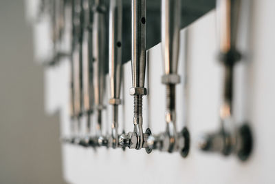 Close-up of metal cables hanging against staircase wall