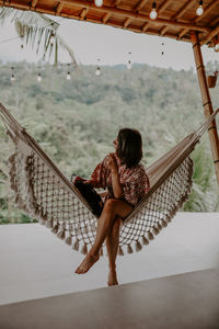 Woman relaxing on hammock at hotel