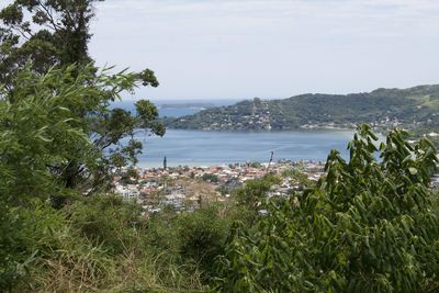 Scenic view of sea by townscape against sky