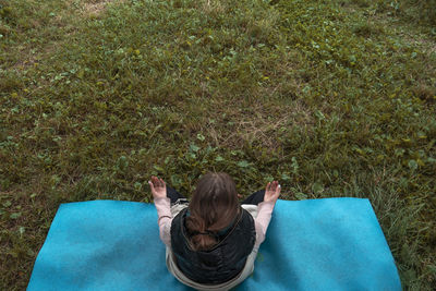 Rear view of woman lying on grass