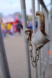 Close-up of rusty chain hanging on metal gate