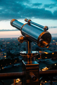 Close-up of coin-operated binoculars against cityscape