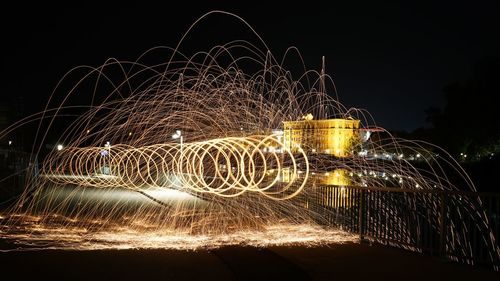 Light trails in city against sky at night