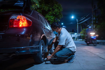 Man working on illuminated street at night