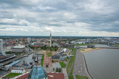 High angle view of city buildings against cloudy sky