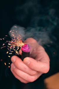 Cropped hand of person holding firecracker