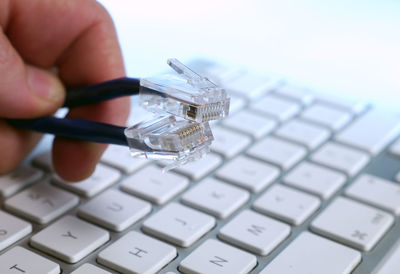 Cropped hand holding computer cables