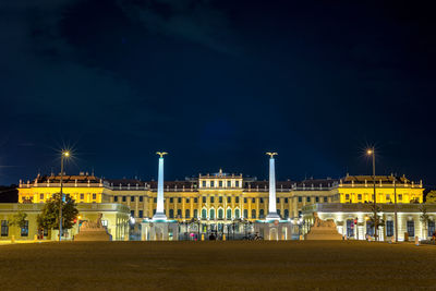 Illuminated buildings against sky at night