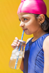 Side view of young woman drinking glass