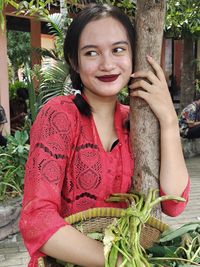 Portrait of young woman holding plant