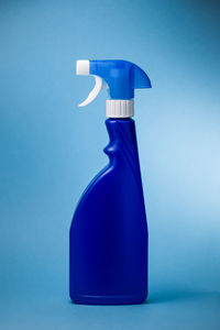 Close-up of spray bottle against blue background