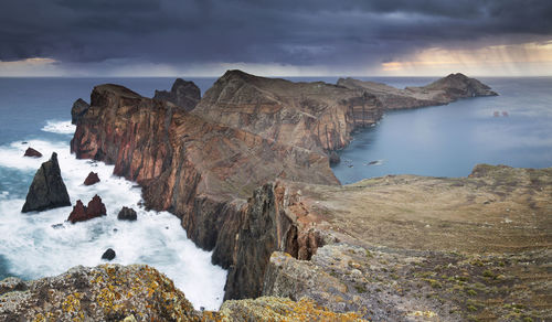 Scenic view of sea and mountains against sky