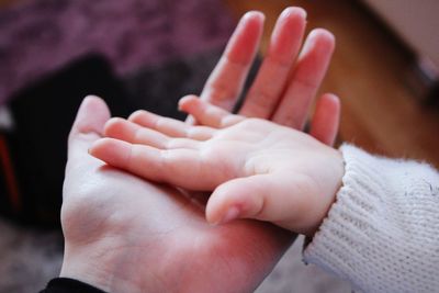 Close-up of mother holding baby hands