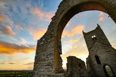 Low angle view of old building against sky during sunset