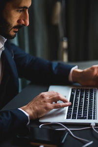 Confident businessman typing on laptop at desk in creative office