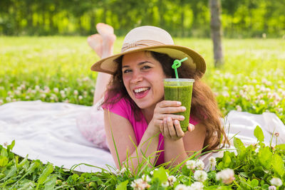 Portrait of a smiling young woman lying on field