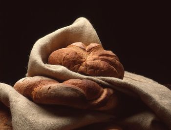 Close-up of bread on sack against black background