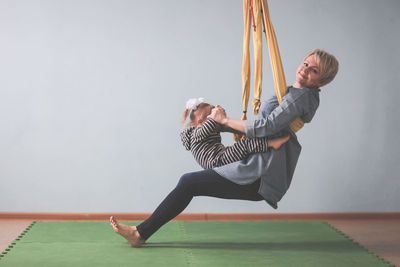 Full length of young woman exercising at home