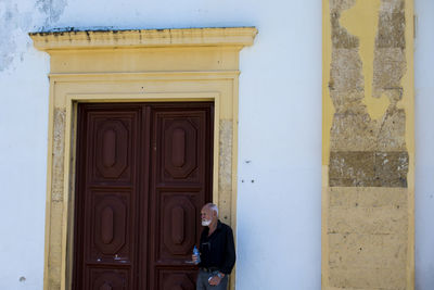 Man standing by door of building