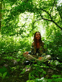 Portrait of a smiling young woman against plants