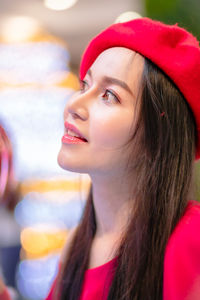 Close-up of thoughtful woman wearing red flat cap