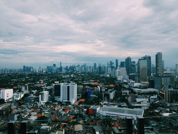 Aerial view of buildings in city against sky