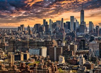 Aerial view of illuminated cityscape against sky during sunset