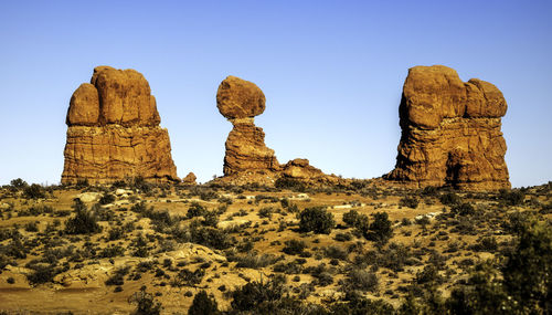 View of rock formations on landscape against clear sky