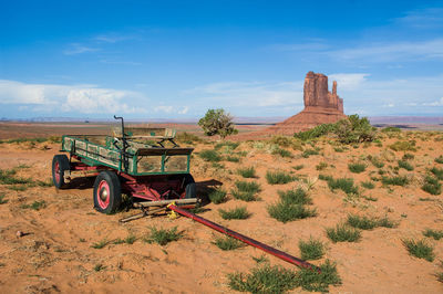 Tractor on field against cloudy sky