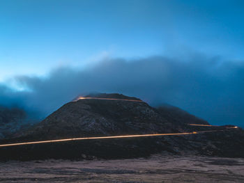 Scenic view of volcanic mountain against sky at dusk