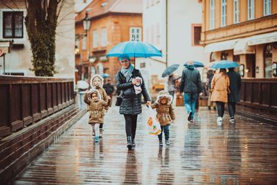 People walking on wet street during rainy season