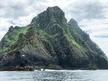 Rock formation by sea against sky